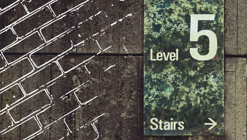 una pared que tiene un letrero que dice level 5, stairs con una flecha